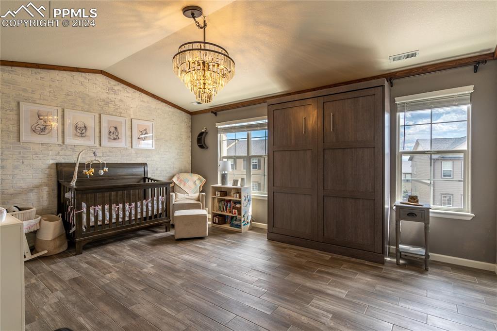 1166 Walters Point Monument, CO 80132 - Photo 13 of 21 a spacious bedroom with a bed and a chandelier