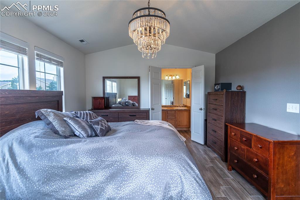 1166 Walters Point Monument, CO 80132 - Photo 9 of 21 a bedroom with a bed and a chandelier