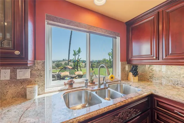 a kitchen with a sink and a large mirror