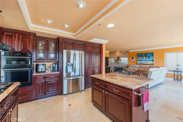 a kitchen with stainless steel appliances granite countertop a stove refrigerator and cabinets