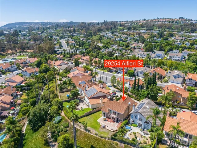 an aerial view of residential houses with outdoor space and trees
