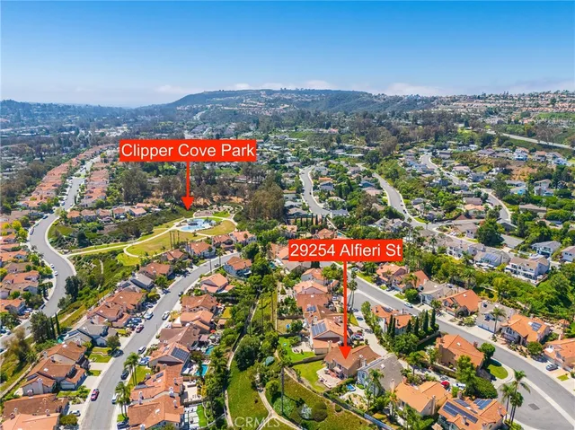 an aerial view of a swimming pool with outdoor seating and yard