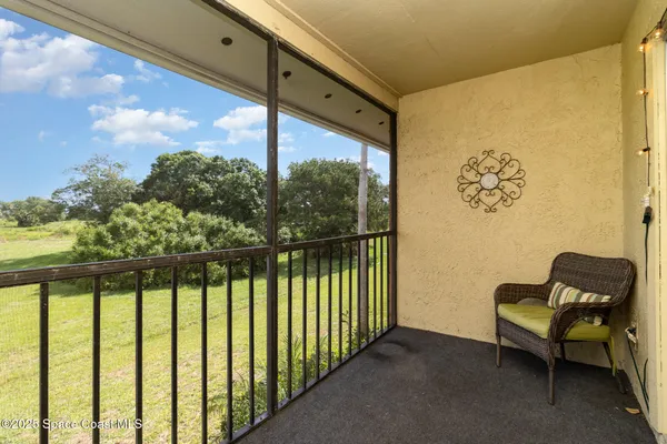 a view of a porch with furniture and a floor to ceiling window