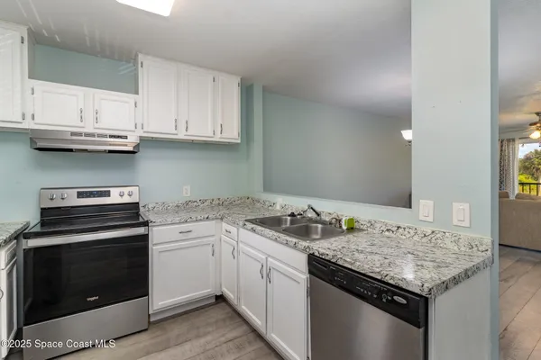 a kitchen with granite countertop stainless steel appliances and white cabinets