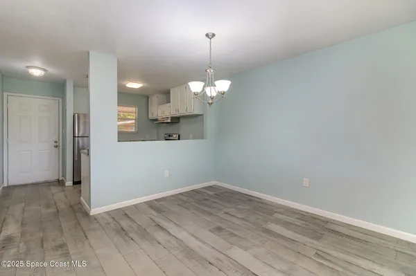 a view of a room with wooden floor and white walls