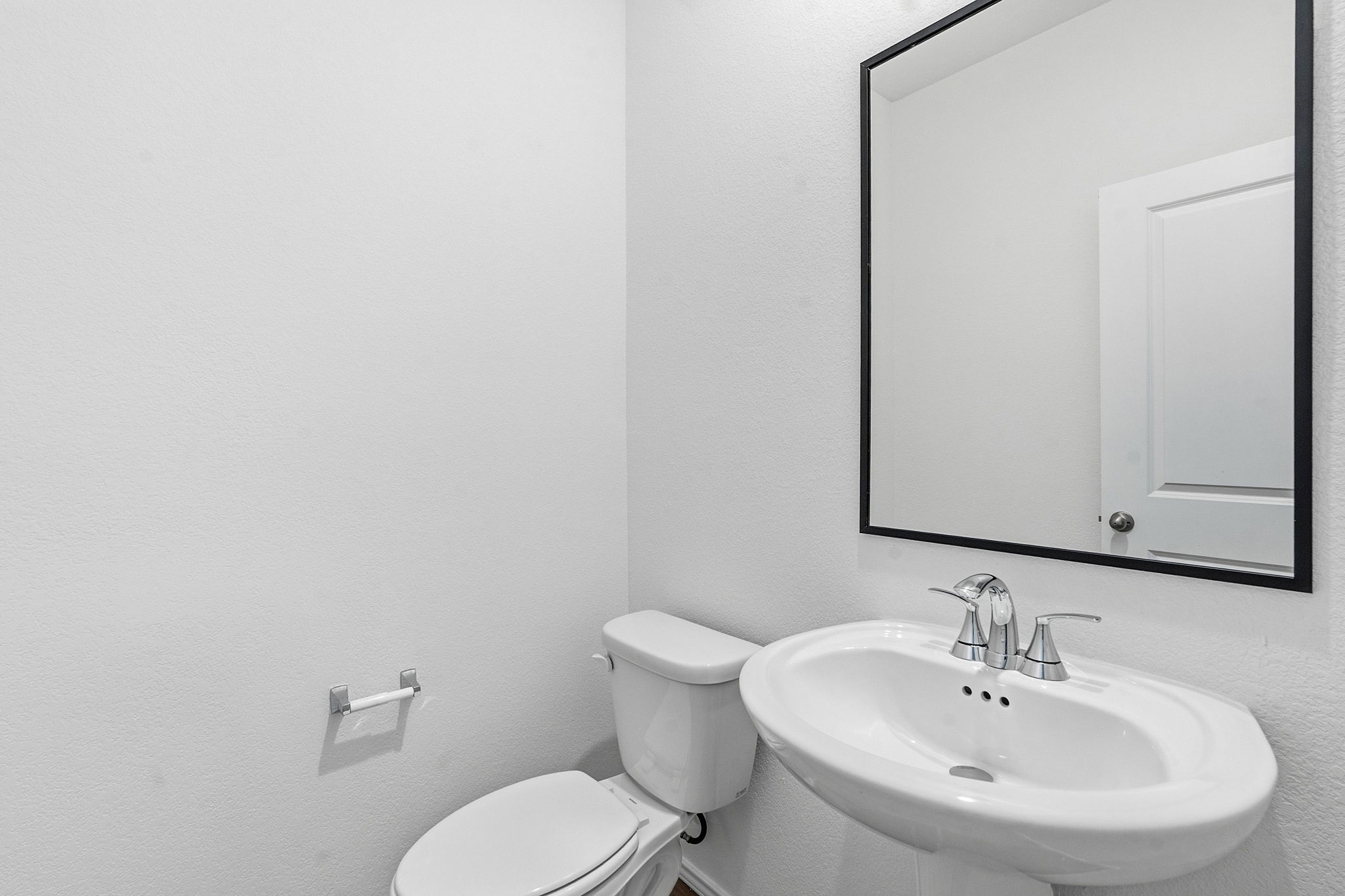 164 Cinnabar Lane, Unit 2 Kyle, TX 78640 - Photo 18 of 21 Pedestal sink with chrome fixtures and a rectangular mirror featuring a black frame