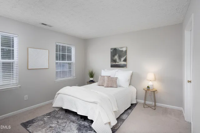 a bedroom with a large bed and a chandelier