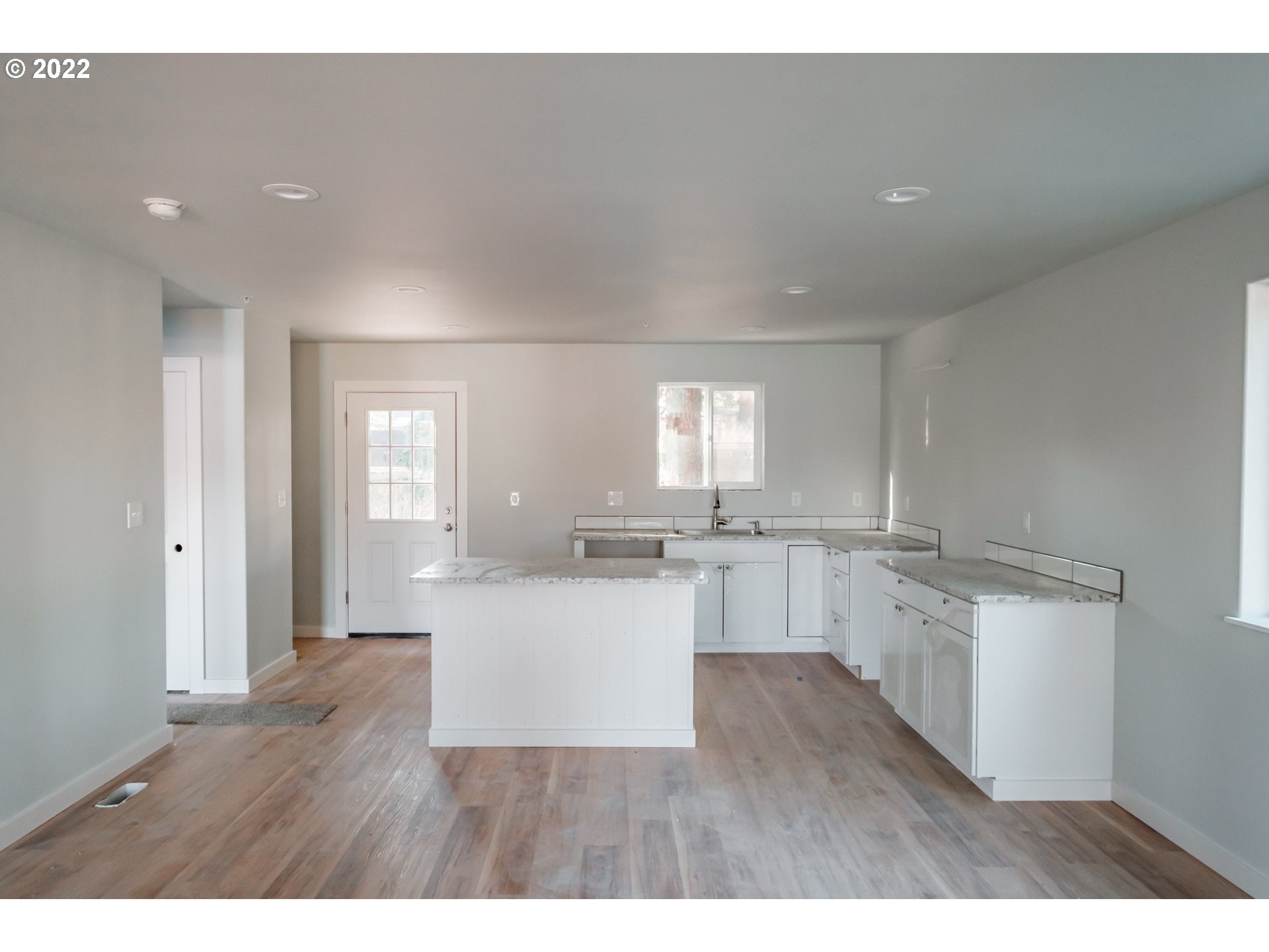 1671 Cooper Street Lebanon, OR 97355 - Photo 3 of 32 a kitchen with a white cabinets and wooden floor