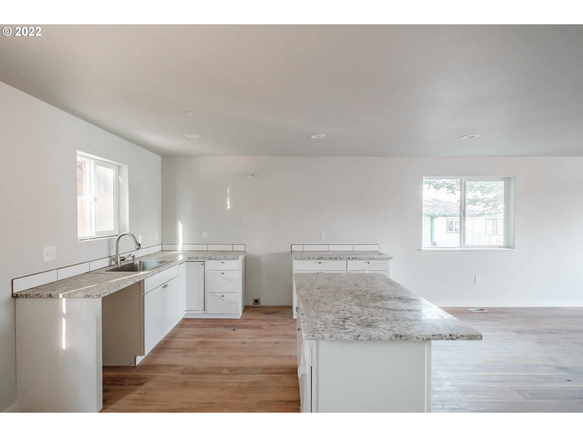 1671 Cooper Street Lebanon, OR 97355 - Photo 4 of 32 a kitchen with kitchen island sink refrigerator and window