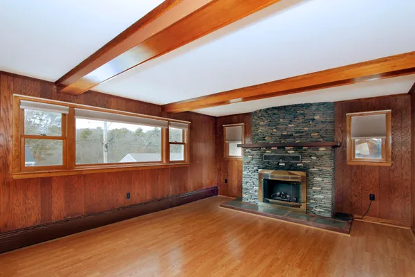 a view of empty room with fireplace and wooden floor