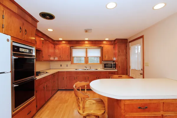 a large kitchen with stainless steel appliances a large counter top