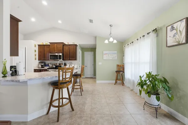 a kitchen with stainless steel appliances a table and chairs in it
