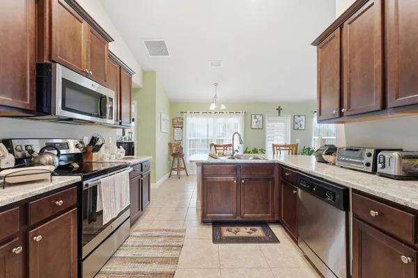 a kitchen with stainless steel appliances granite countertop a sink stove and cabinets