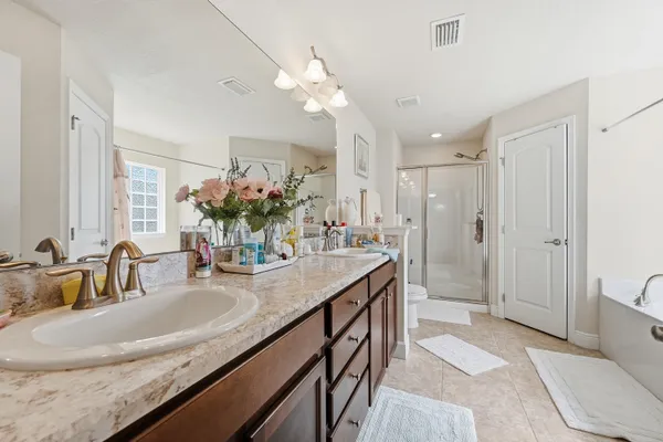 a bathroom with a granite countertop sink a large mirror and a shower