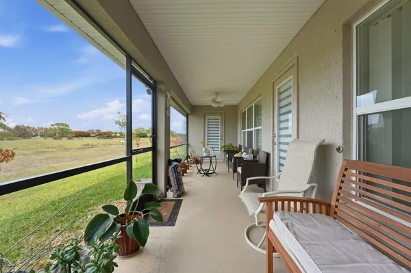 a balcony with chairs and wooden floor