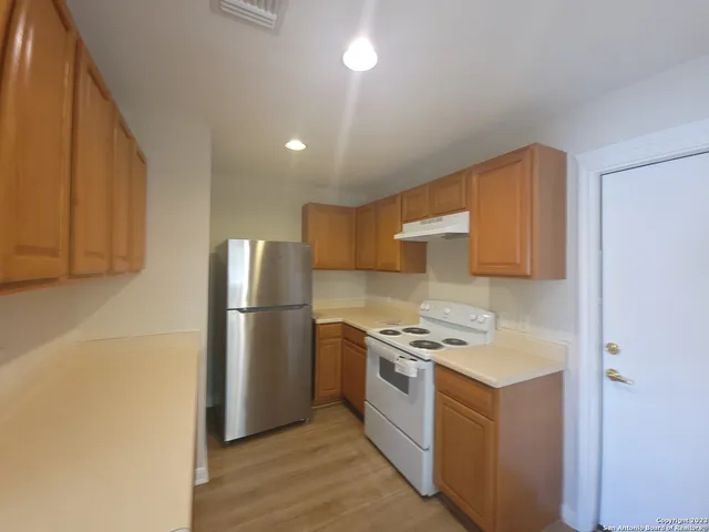 a kitchen with a stove a refrigerator and a sink