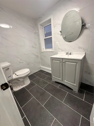 a bathroom with a double vanity sink mirror and toilet