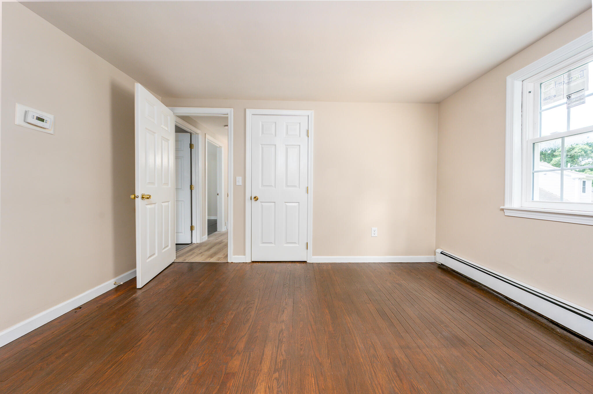 65 Elliott Road Centerville, MA 02632 - Photo 21 of 36 a view of an empty room with wooden floor and a window