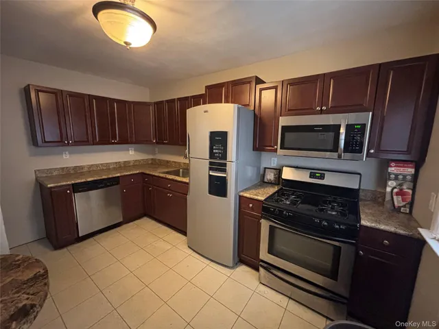a kitchen with stainless steel appliances granite countertop a stove microwave and refrigerator