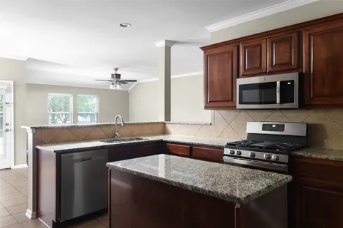 a kitchen with stainless steel appliances granite countertop a sink stove and cabinets