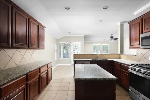 a kitchen with granite countertop stainless steel appliances and wooden cabinets