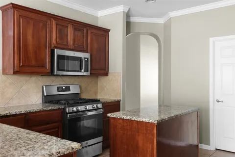 a kitchen with granite countertop a sink and a stove