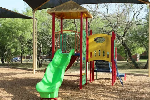 a front view of a house with a garden and trees