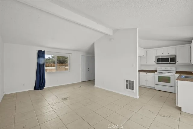 a view of a kitchen with white cabinets and white appliances