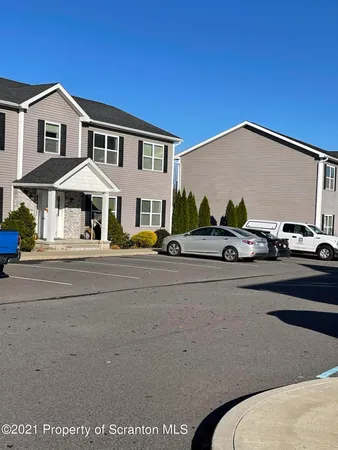 a couple of cars parked in front of a house