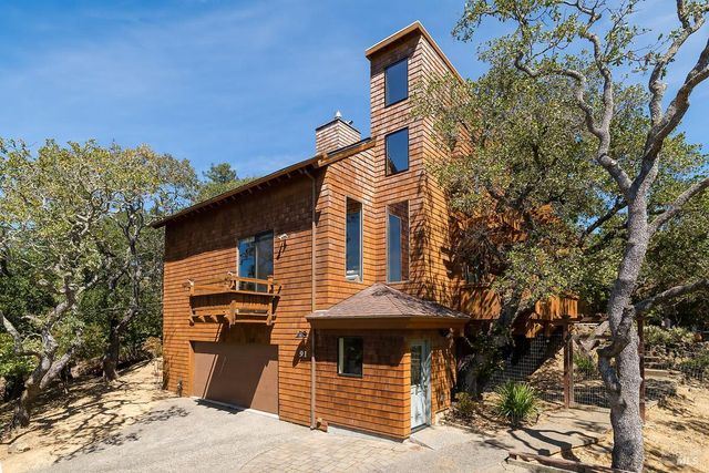 a front view of a house with a tree