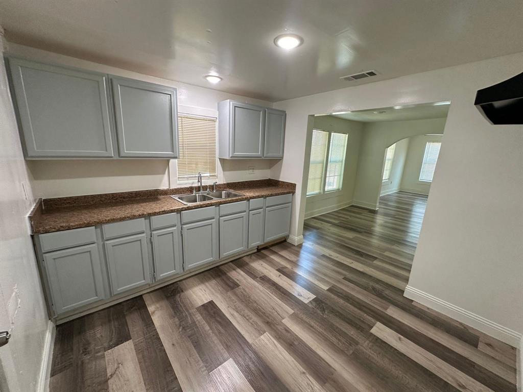 a large kitchen with stainless steel appliances granite countertop a sink and cabinets