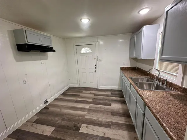 a kitchen with granite countertop a sink and a stove top oven