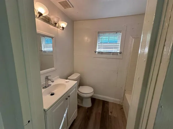 a bathroom with a sink a toilet and a mirror