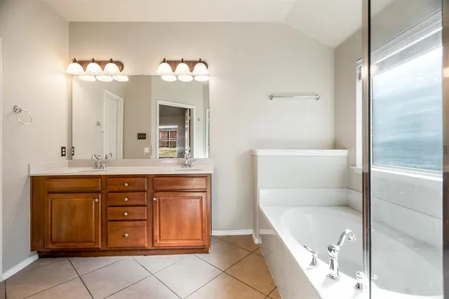 a bathroom with a tub sink and mirror