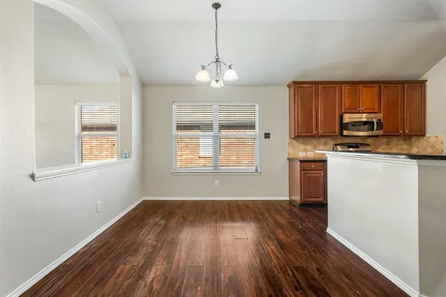 a kitchen with wooden floors and white cabinets