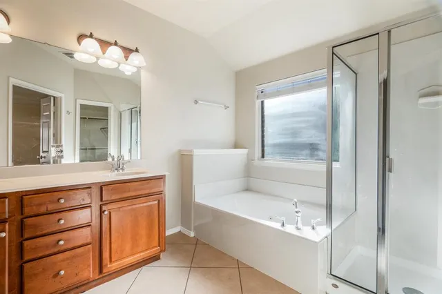 a bathroom with a tub sink and mirror
