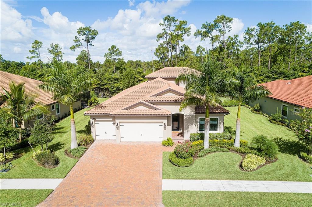 a view of a white house with a yard and potted plants