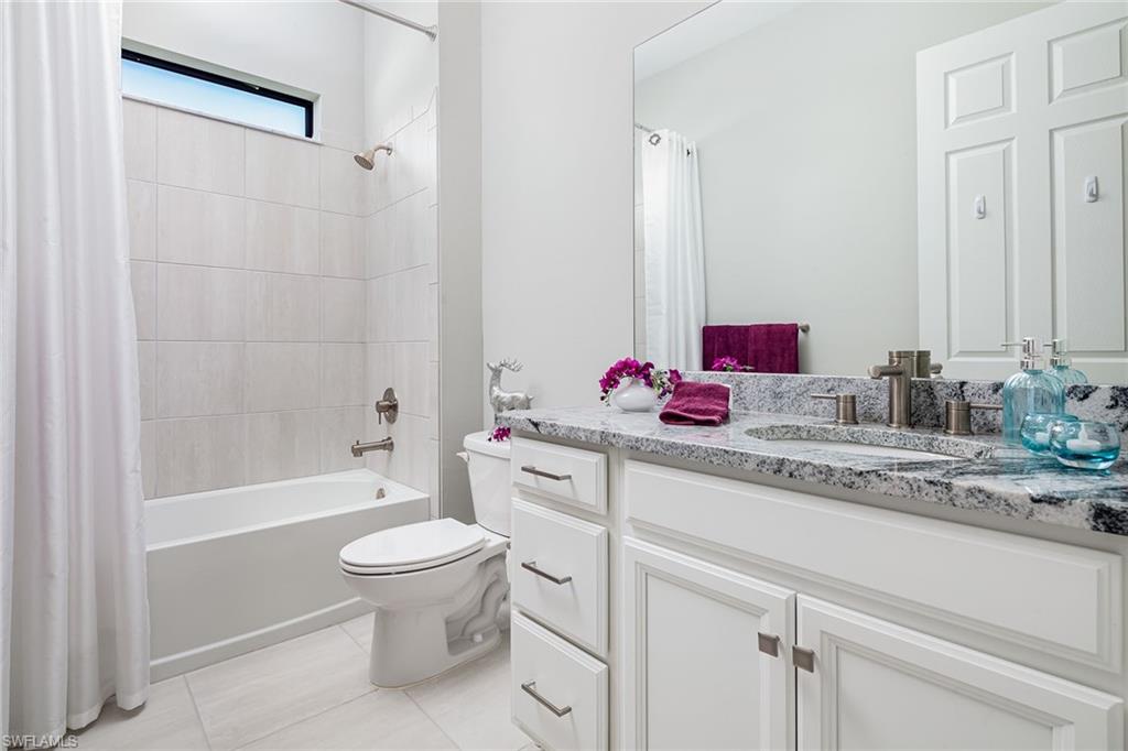 1423 Mockingbird Drive Naples, FL 34120 - Photo 19 of 32 a bathroom with a granite countertop sink mirror vanity and toilet