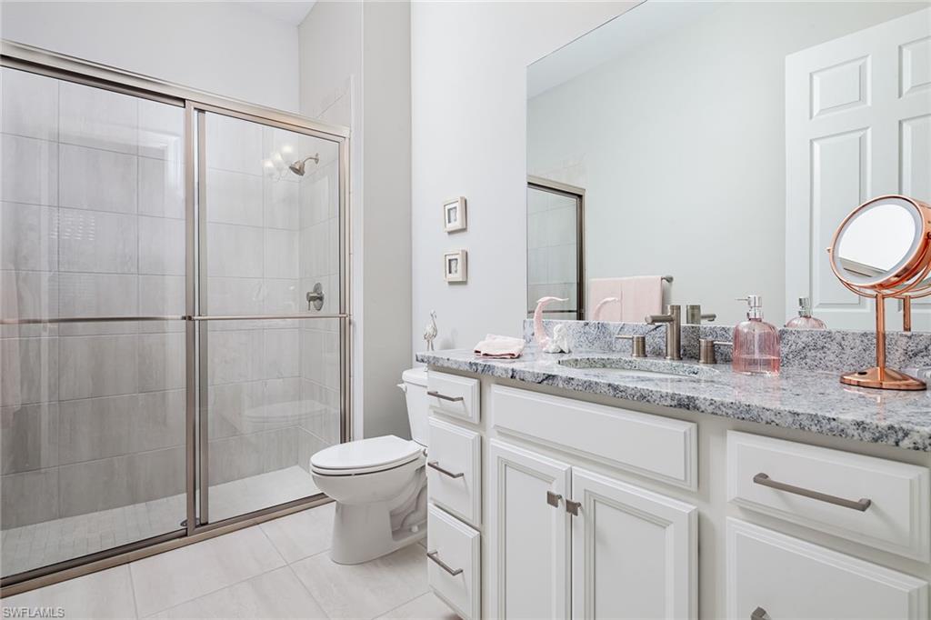 1423 Mockingbird Drive Naples, FL 34120 - Photo 22 of 32 a bathroom with a granite countertop sink a toilet and a shower