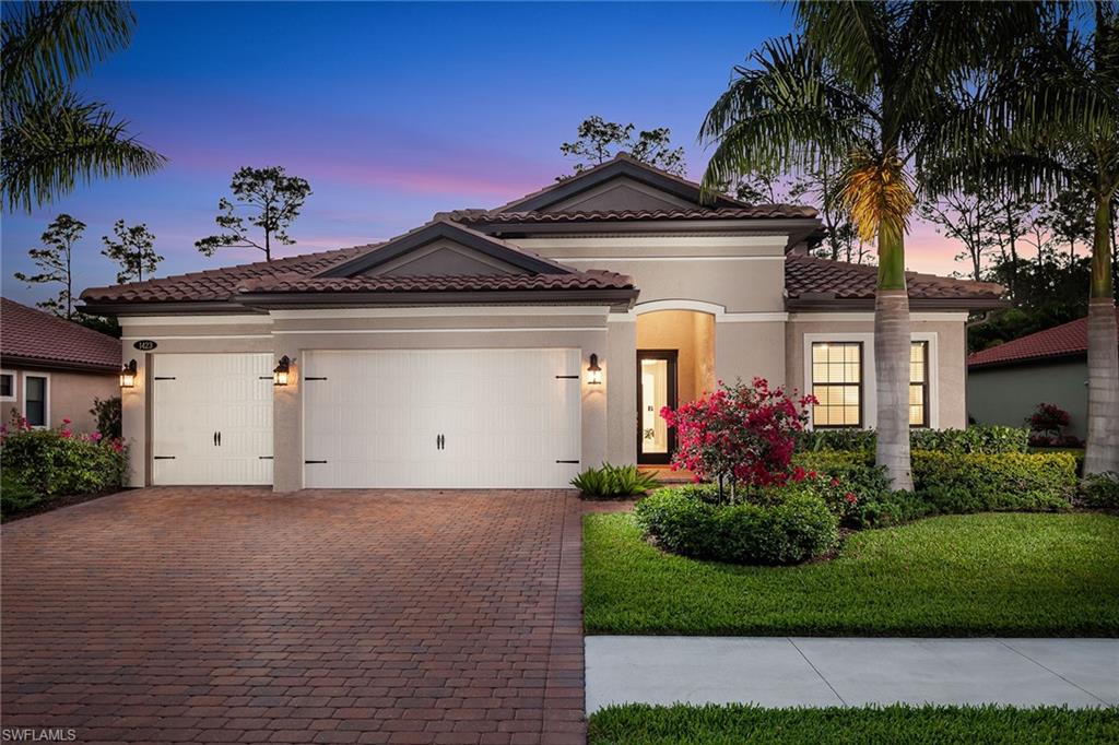 1423 Mockingbird Drive Naples, FL 34120 - Photo 3 of 32 a front view of a house with a garden