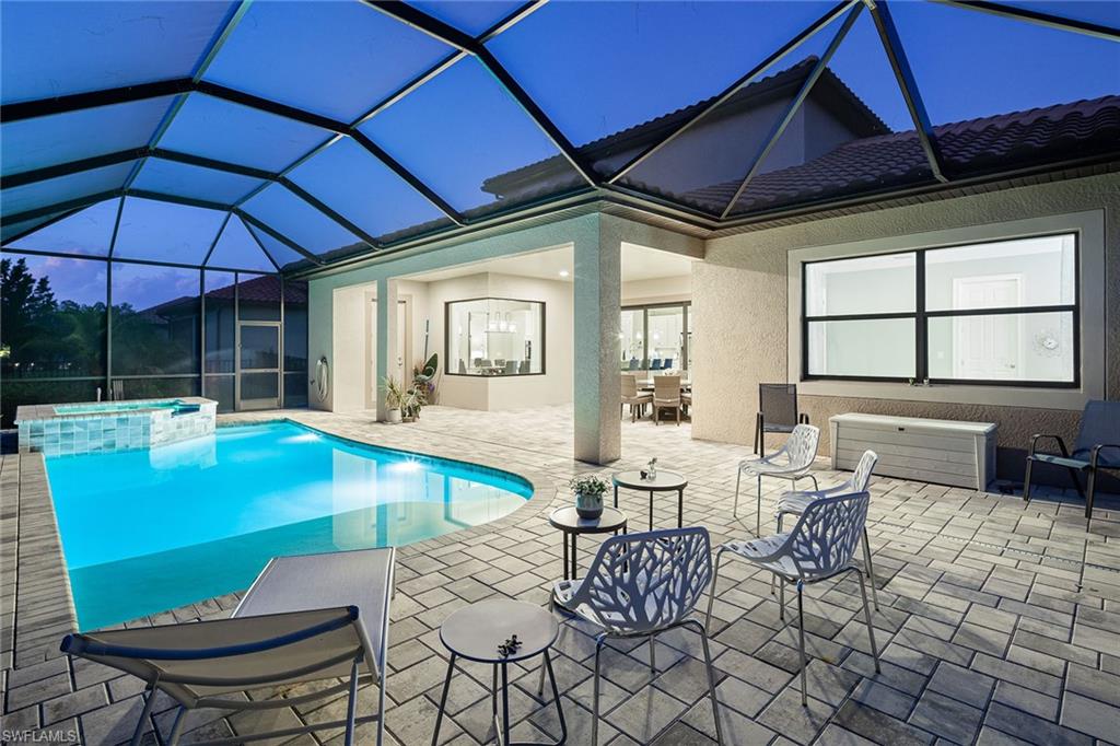 1423 Mockingbird Drive Naples, FL 34120 - Photo 5 of 32 a outdoor dining space with furniture and umbrella