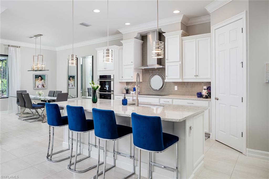1423 Mockingbird Drive Naples, FL 34120 - Photo 10 of 32 a kitchen with stainless steel appliances kitchen island granite countertop a sink and cabinets