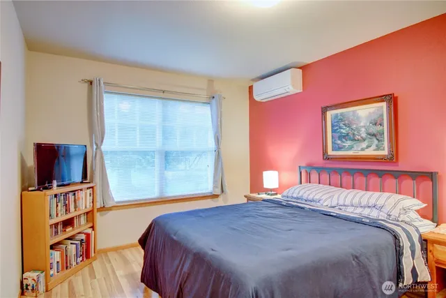 a bedroom with a large bed and a painting on the wall