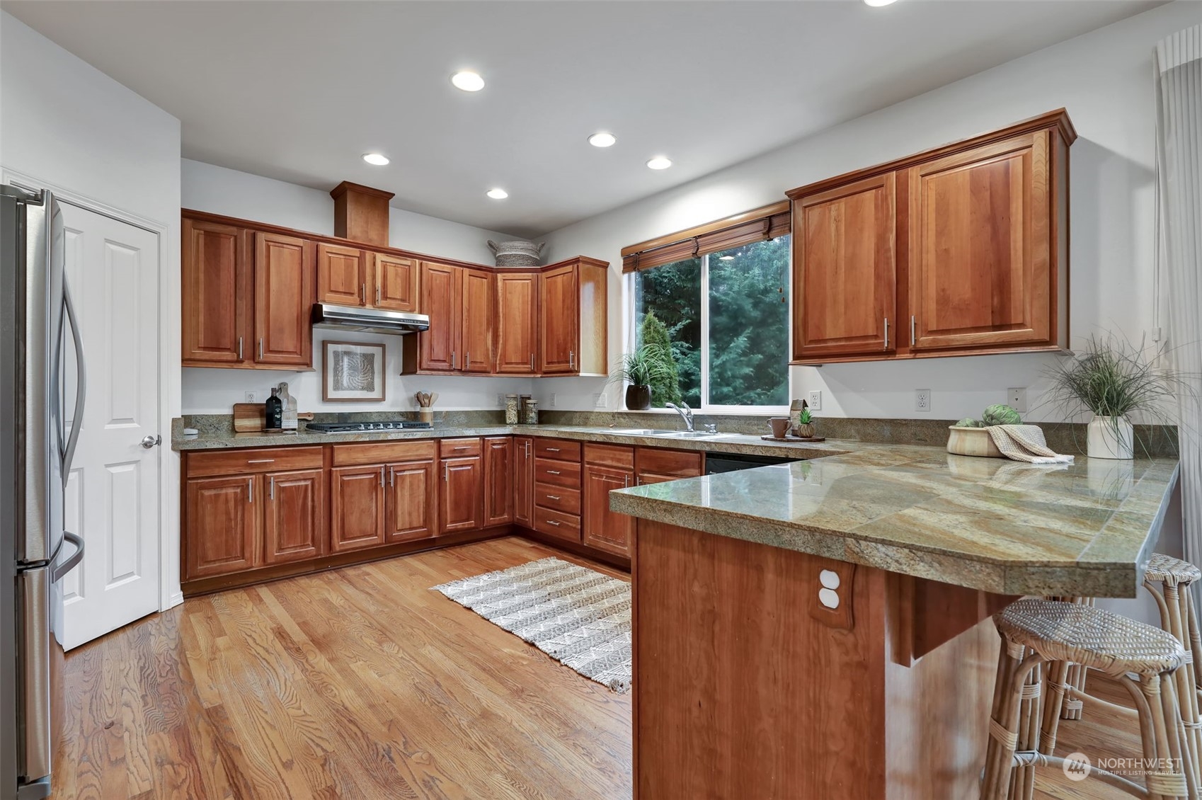 3714 Lincoln Court Northeast Renton, WA 98056 - Photo 9 of 33 a kitchen with kitchen island granite countertop wooden cabinets a sink a stove a refrigerator and island with wooden floor