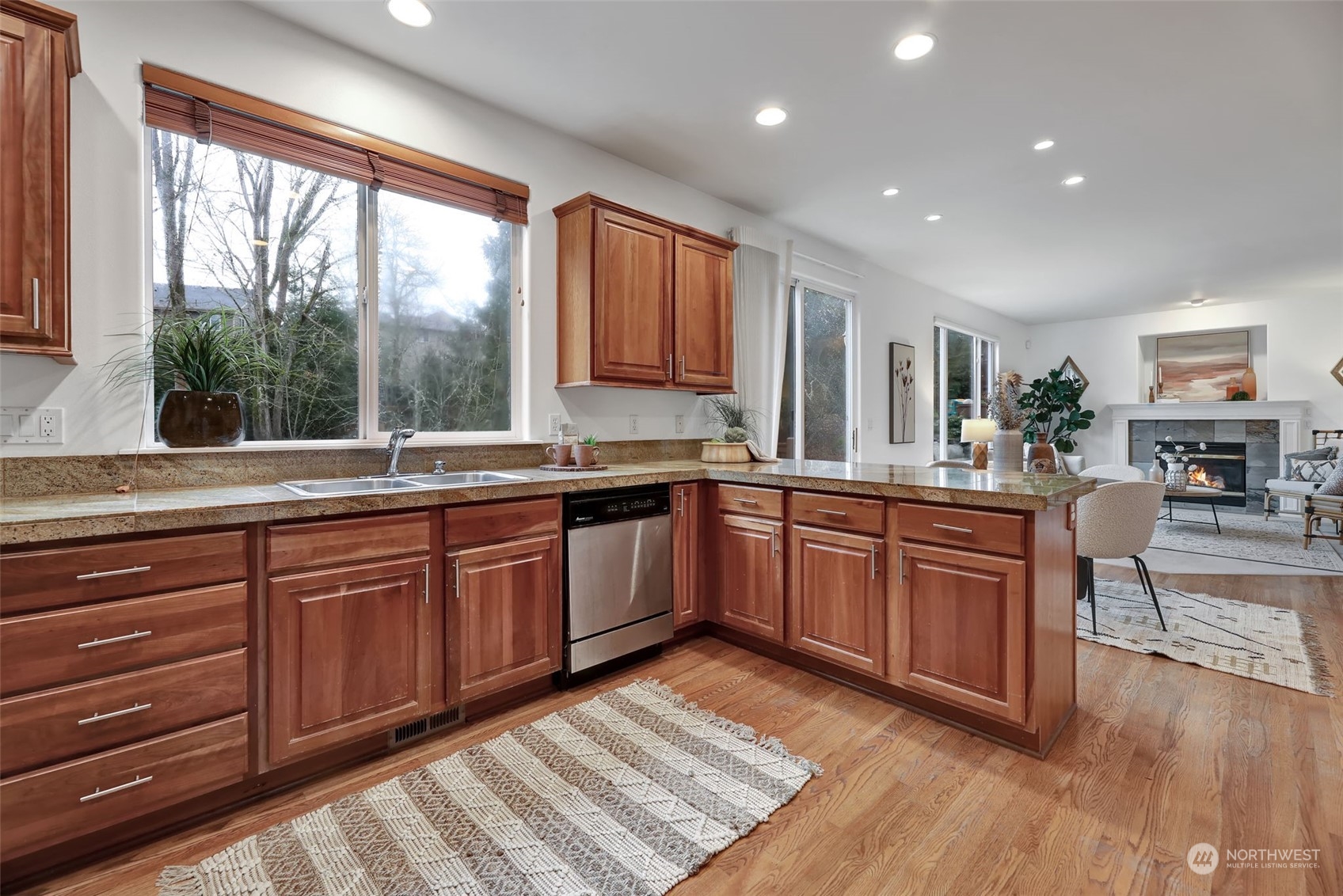 3714 Lincoln Court Northeast Renton, WA 98056 - Photo 10 of 33 a large kitchen with stainless steel appliances granite countertop a stove a sink dishwasher a microwave oven and a dining table with wooden floor
