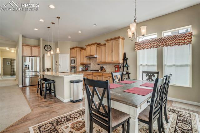 12442 Carmel Ridge Road Colorado Springs, CO 80921 - Photo 13 of 50 Dining space with sink and light hardwood / wood-style floors