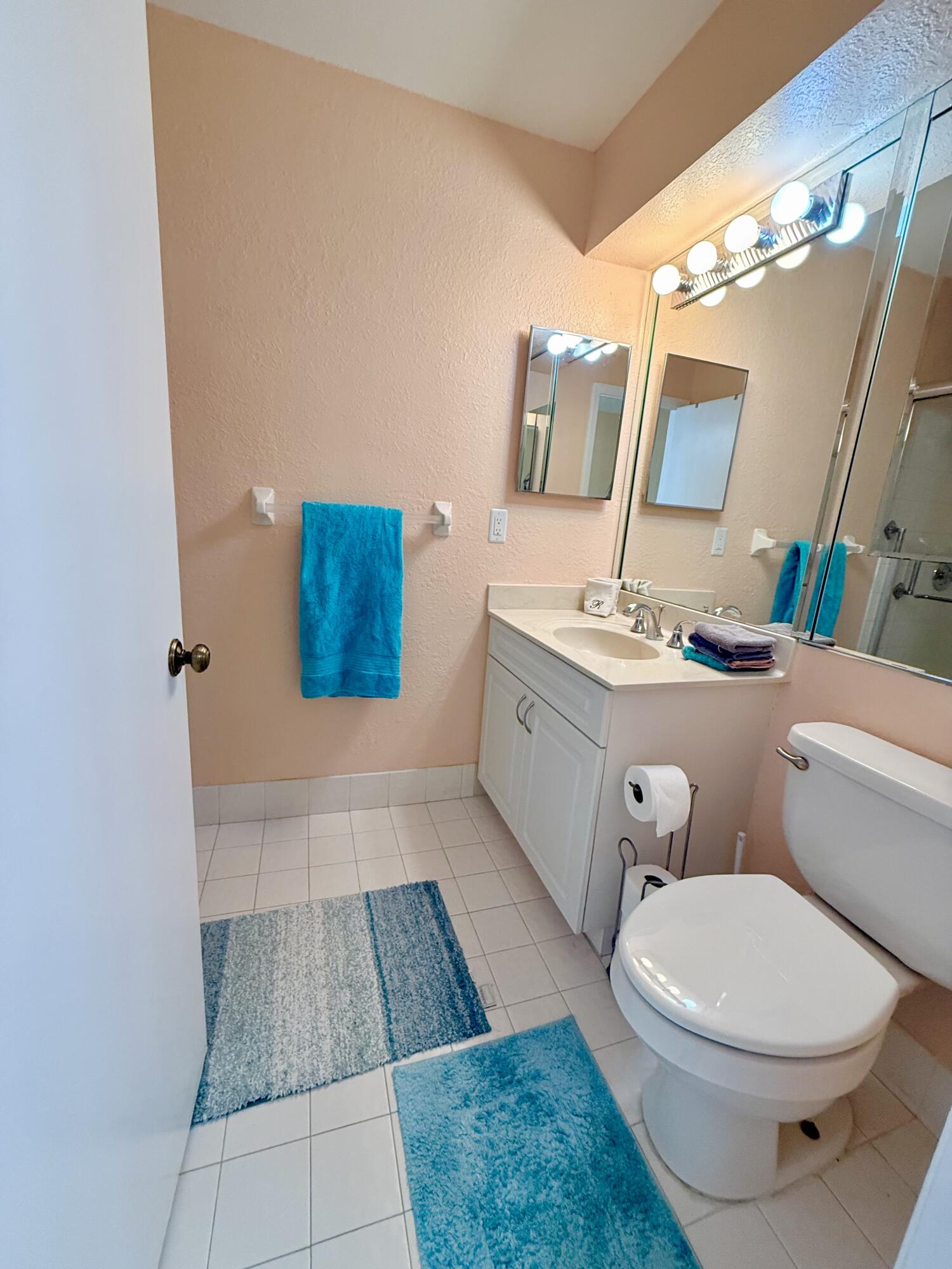 7024 Golf Pointe Circle Tamarac, FL 33321 - Photo 23 of 28 a bathroom with a toilet a sink and mirror