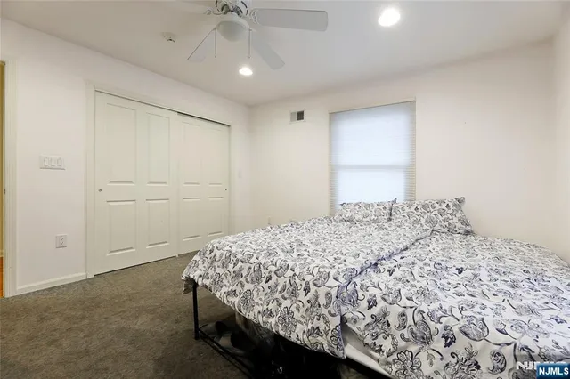 a bedroom with a bed and a chandelier fan