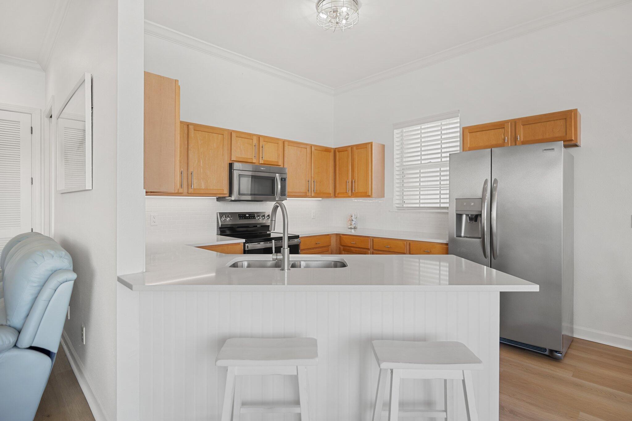2221 Crystal Cove Lane, Unit 2221 Miramar Beach, FL 32550 - Photo 17 of 32 a kitchen with stainless steel appliances a sink a microwave a refrigerator and cabinets