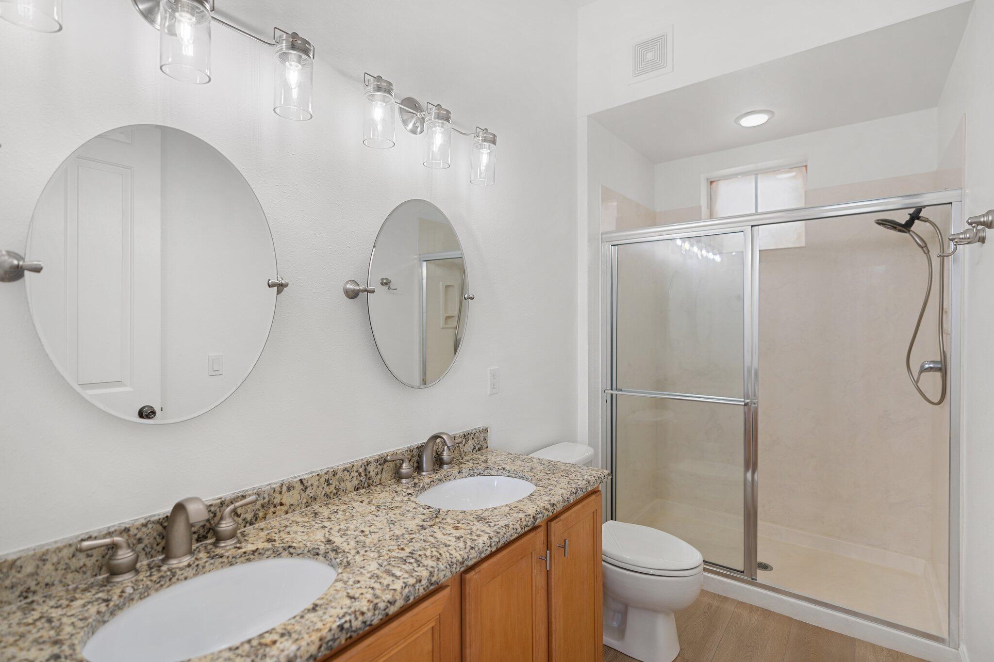 2221 Crystal Cove Lane, Unit 2221 Miramar Beach, FL 32550 - Photo 24 of 32 a bathroom with a granite countertop sink a toilet and a mirror